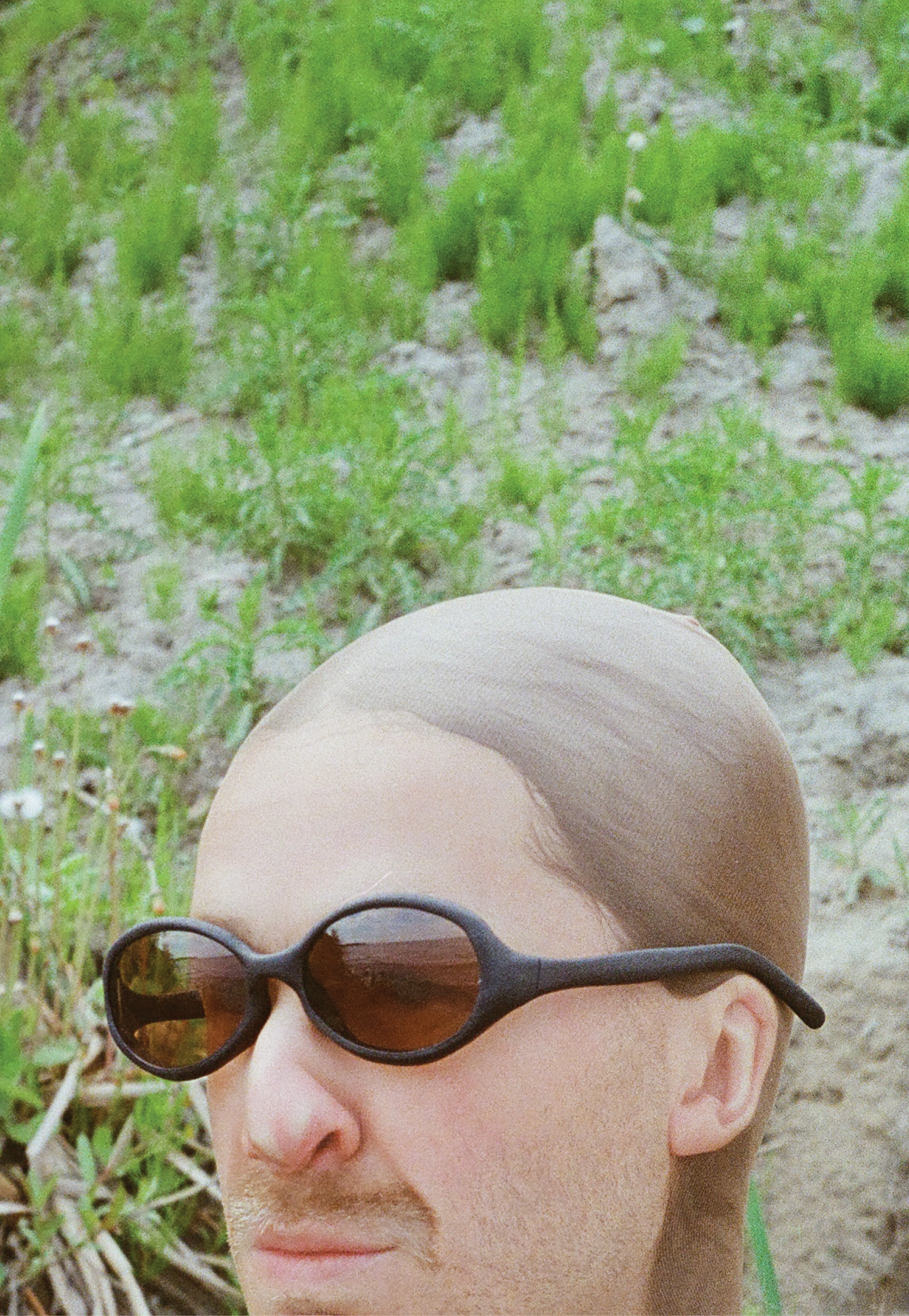 3D render of a bald model wearing black sunglasses with transparent grey lenses