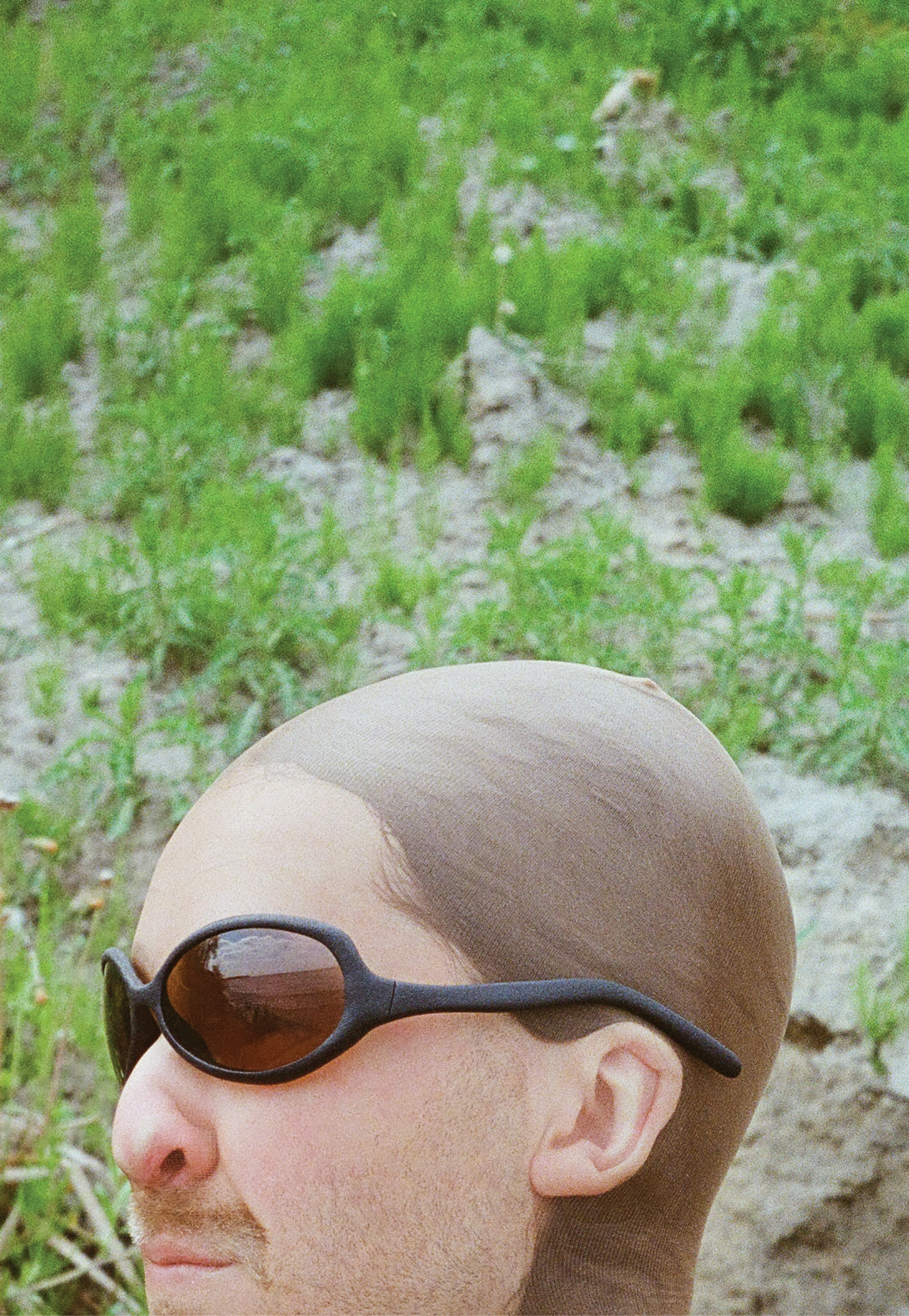 3D render of a bald model wearing black sunglasses with transparent grey lenses